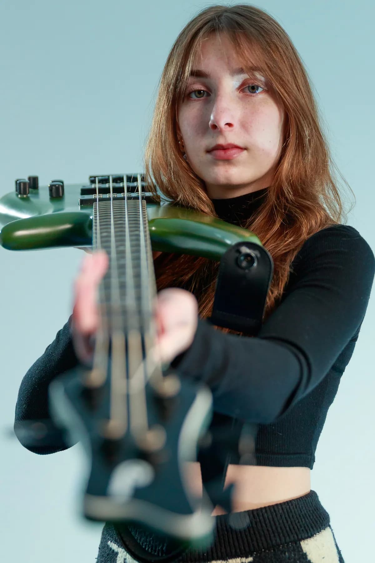 Tori Morley behind the strings of a green bass.